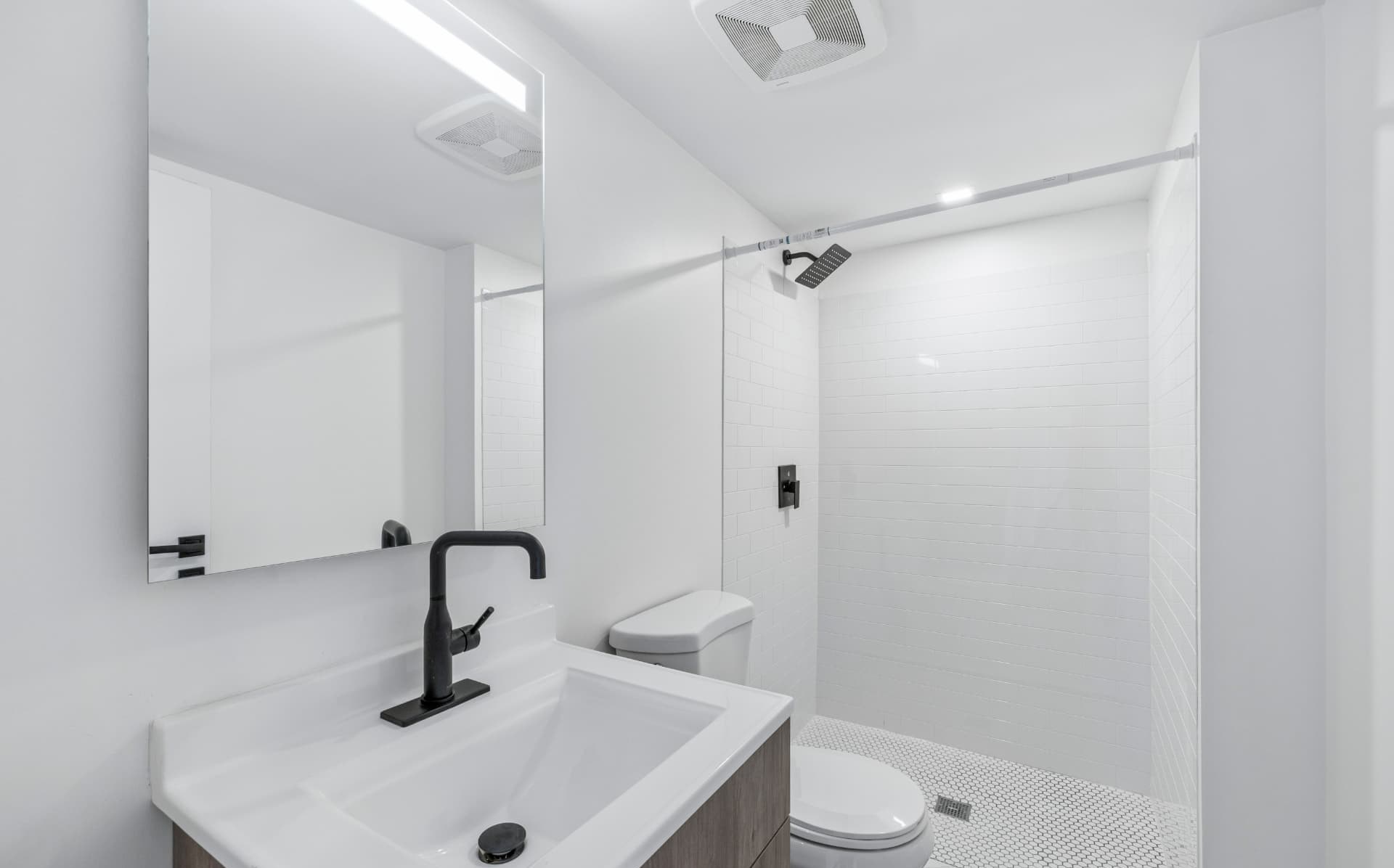 Modern bathroom with walk-in tiled shower and black fixtures